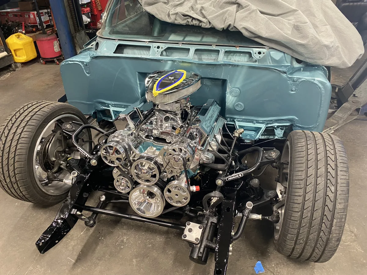 Teal vintage car with restored engine and custom wheels