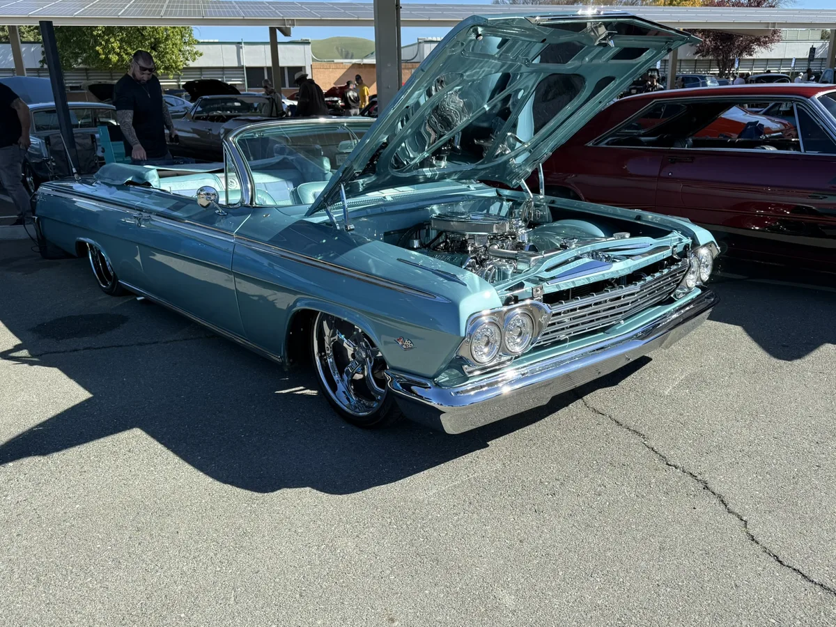 Teal convertible with chrome details at car show