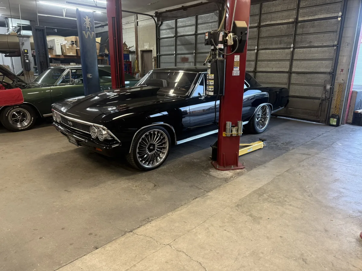 Red 1955 Chevrolet with chrome trim in workshop